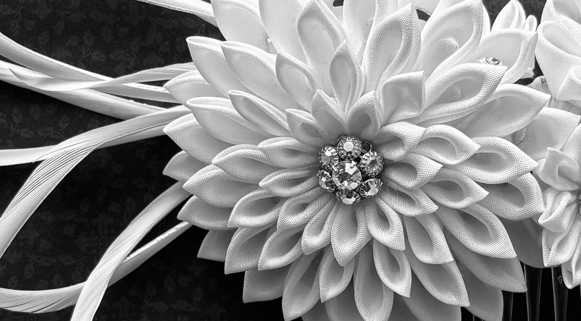 Floral hair comb with white flowers and rhinestones on a dark background